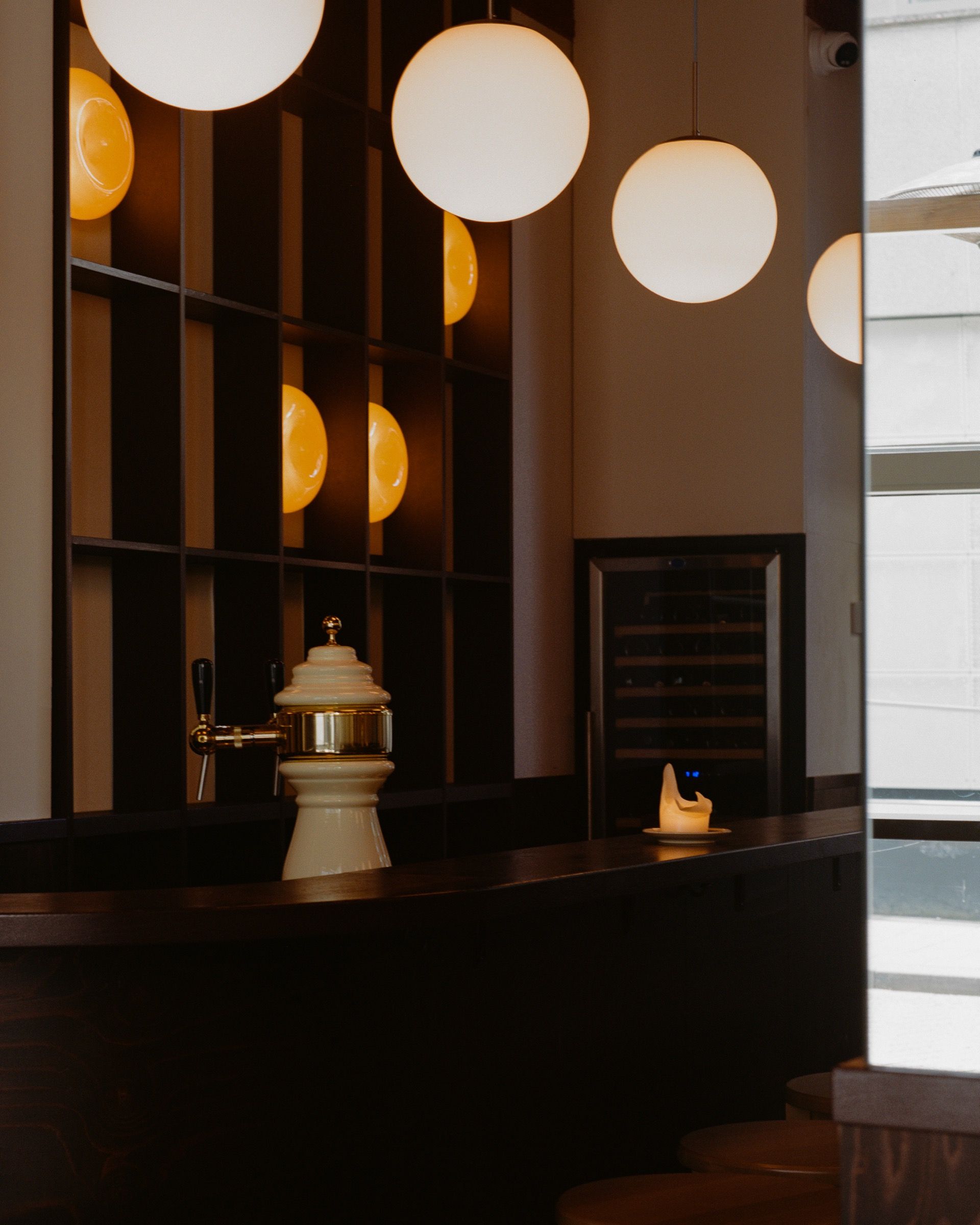 Bar in dark timber with opal glass globe lights, Bar Goesting Tilburg