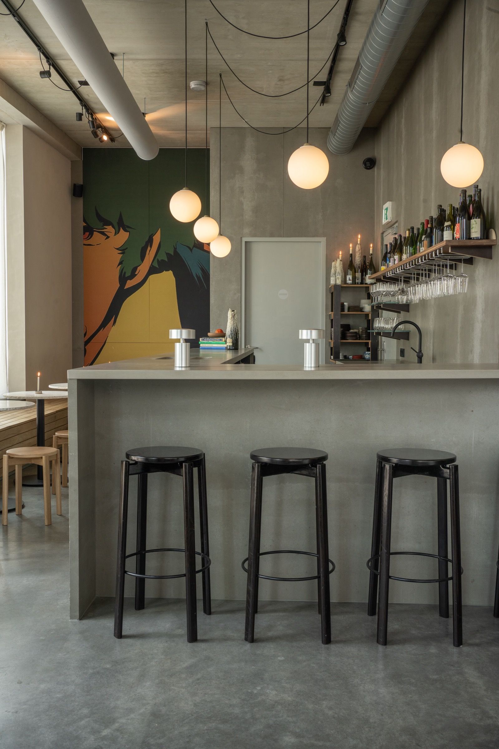Poured concrete shop counter with opal glass globe lights, Bottleshop Amsterdam
